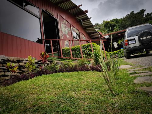 a car parked in front of a red building at Greemount Hotel in Monteverde Costa Rica