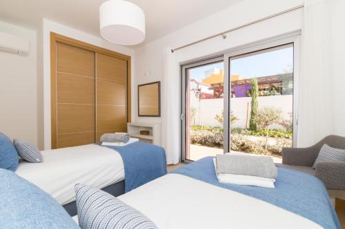 a bedroom with two beds and a large window at Beach Condominium in Lagos