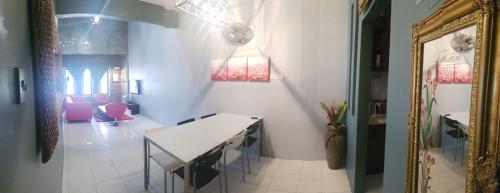 a dining room with a white table and pink chairs at Andak Home2stay in Ipoh