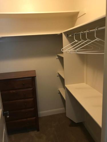a walk in closet with white cabinets and a drawer at Hurricane Hill Home in Hurricane