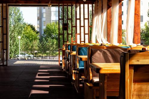 una fila de mesas y bancos en un edificio en AYKUN Hotel by AG Hotels Group en Astaná