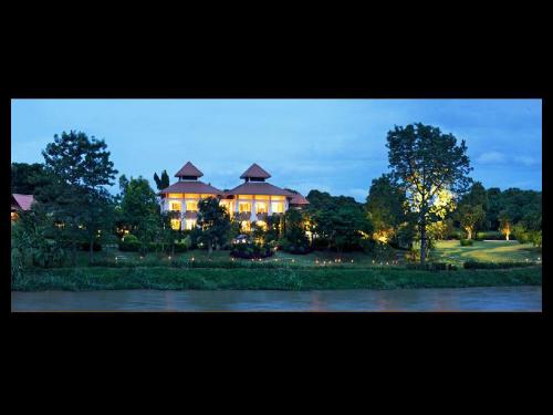 a large house is lit up at night at Fueng Fah Riverside Gardens Resort in Mae Rim
