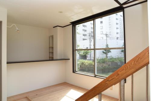 a room with a large window and a staircase at 駐車場無料 Nagoya Hostel The Three Smiles Free Car Park in Nagoya