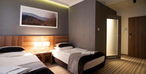 a hotel room with two beds and a mirror at Montis Hotel & Spa in Poniatowa
