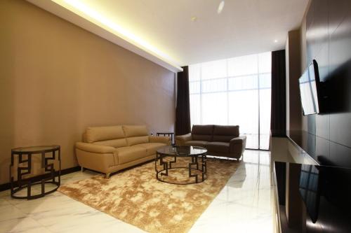 a living room with a couch and a table at Grand Karlita Hotel Purwokerto in Purwokerto