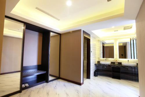 a bathroom with two sinks and two mirrors at Grand Karlita Hotel Purwokerto in Purwokerto
