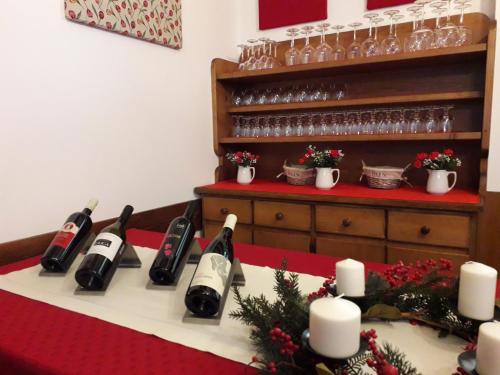 a table with wine bottles and candles on it at Albergo al Sole in Val di Zoldo