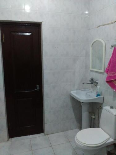 a bathroom with a white toilet and a sink at "Green way" Guest house in Tbilisi City