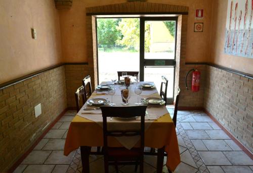 una sala da pranzo con tavolo, sedie e finestra di Hotel Fontana a Rubiera