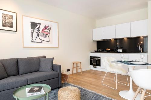 a living room with a couch and a kitchen at PREMIER SUITES Antwerp in Antwerp