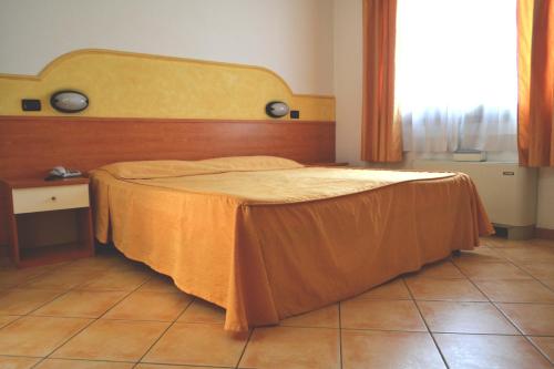 una camera da letto con un letto con sopra un lenzuolo arancione di Hotel Fontana a Rubiera