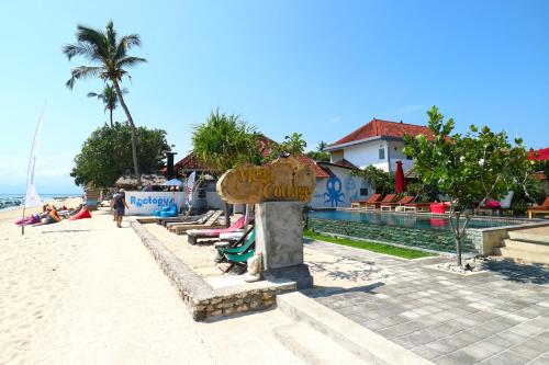 a sign on the beach next to a resort at Mega Cottages in Nusa Lembongan