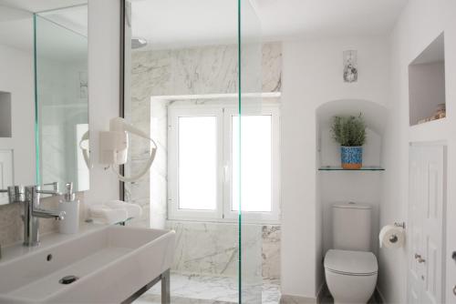 ein weißes Bad mit einem Waschbecken und einem WC in der Unterkunft Theotoki Liston Suite in Korfu-Stadt