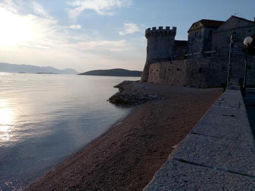 a castle on the shore of a body of water at Accommodation Old Town Vitaic in Korčula