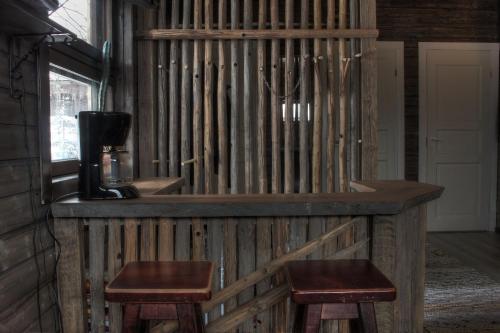 een bar in een kamer met 2 krukken bij Olkka ranch in Mustakulkkula