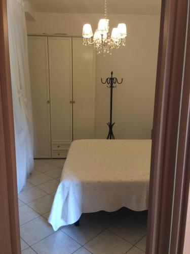 a bedroom with a bed and a chandelier at Residence Villa degli Ulivi in Bertinoro