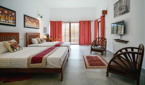 a bedroom with two beds and a television in it at Atelier in Kandy