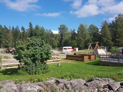 a park with a wooden fence and a playground at Haga gård och Stall in Herräng