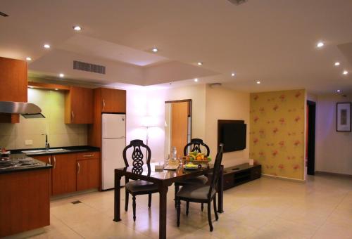 a kitchen with a table and chairs in a room at City Rose Hotel Suites in Amman