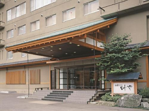 a building with stairs in front of a building at Itoen Hotel Iizakakanouya in Fukushima