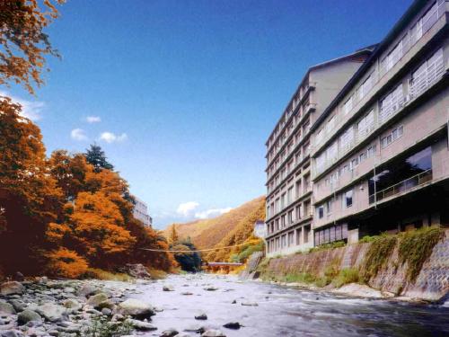 a river next to a building next to a building at Itoen Hotel Iizakakanouya in Fukushima
