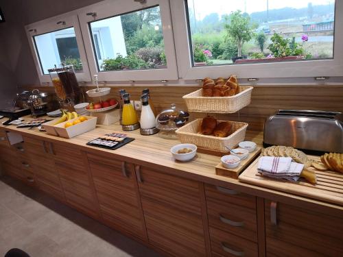 a kitchen counter with bread and other foods on it at Best Hotel Bordeaux Sud in Villenave-dʼOrnon
