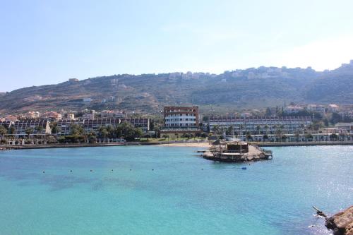a large body of water with a beach and buildings at Miramar Hotel Resort and Spa in Trâblous