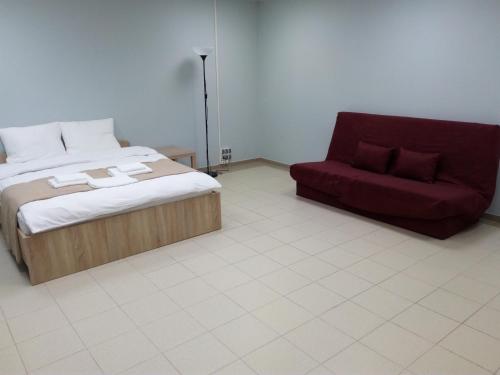 バラシハにあるApartament on Lenina 37のベッドルーム1室(ベッド1台、赤いソファ付)