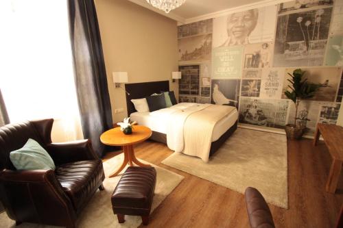WeißenseeにあるHotel Promenadenhofのベッドとテーブルと椅子のあるホテルの部屋
