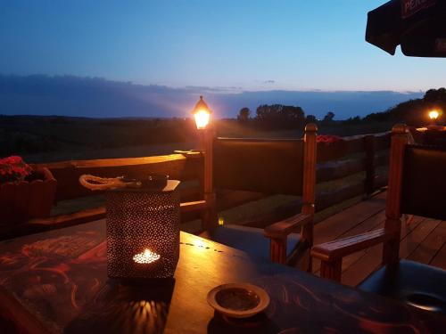 a table and two chairs on a deck with the sunset at Dwór na Wichrowym Wzgórzu in Przybysławice