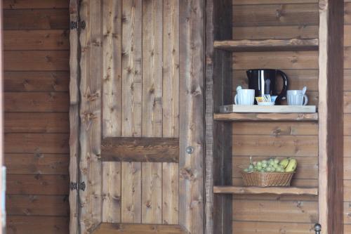 eine Holzwand mit einem Regal und einem Obstkorb in der Unterkunft Villaggio San Demetrio in Carlentini