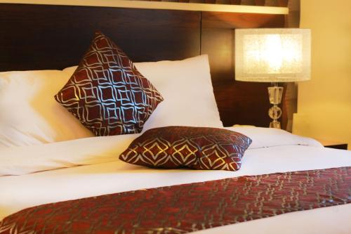 a bed with two pillows on top of it at City Rose Hotel Suites in Amman