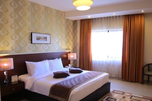 a hotel room with a large bed with a window at City Rose Hotel Suites in Amman