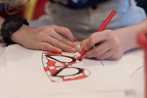 a person cutting a piece of paper with a pair of scissors at Hotel Alpenhof in Sankt Jakob in Defereggen