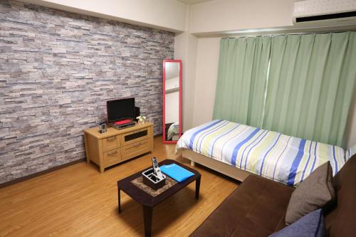 a bedroom with a bed and a couch and a tv at Free bike & free WIFI 203 Take it easy in Kyoto
