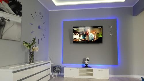 sala de estar con TV en una pared púrpura en Apartamenty SOFIJA Deluxe Centrum, en Zielona Góra