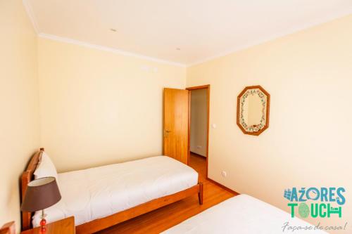 アングラ・ド・エロイーズモにあるQuinta da Conceiçãoのベッドルーム1室(ベッド1台、壁掛け鏡付)
