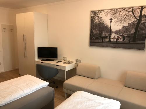 a room with a desk with a computer and a bed at Gasthof "Zur Kanne" in Sankt Florian bei Linz