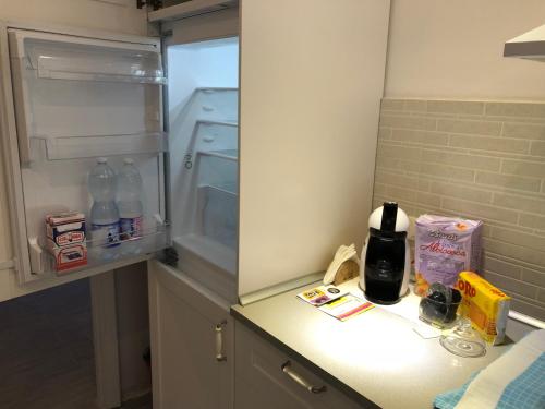 a small kitchen with an empty refrigerator and a counter at Casa Bianca Laigueglia in Laigueglia