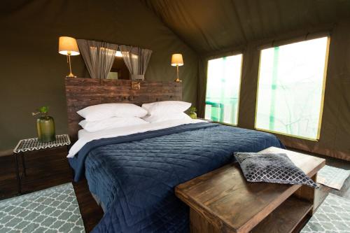 a bedroom with a large bed with a blue blanket at Parsons Hilltop Safari Camp in Balule Game Reserve