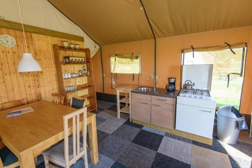 a kitchen and dining table in a tent at Boerderij Halfweg in West-Terschelling