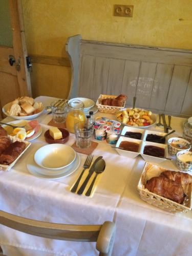 a table with a white table cloth with food on it at Les Deux Rives in Cierp