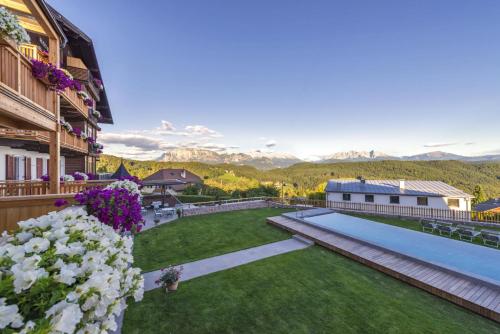 a view of a yard with a swimming pool and mountains at Hotel Regina in Soprabolzano