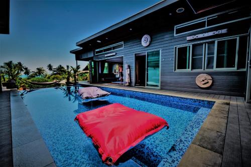 a pool with a red float in front of a house at Stunning villa with ocean views and free car in Lamai