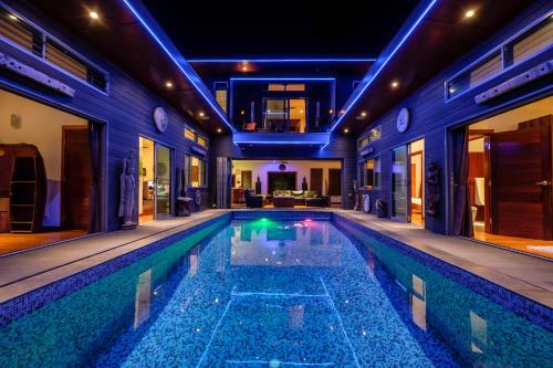 a swimming pool in a house with lights on it at Stunning villa with ocean views and free car in Lamai