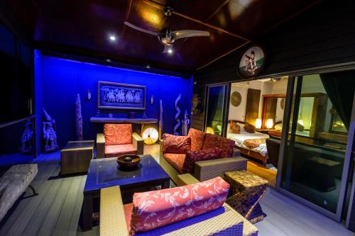 a living room with a couch and a table at Stunning villa with ocean views and free car in Lamai