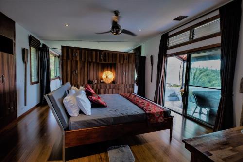 a bedroom with a bed with pillows on it at Stunning villa with ocean views and free car in Lamai