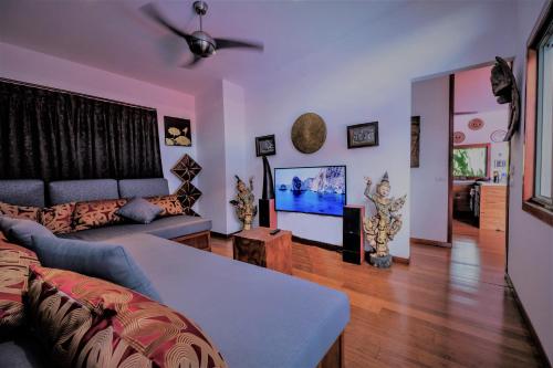 a living room with a couch and a flat screen tv at Stunning villa with ocean views and free car in Lamai