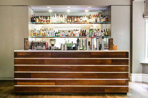 a bar in a room with a shelf of alcohol at The Green House in Bournemouth