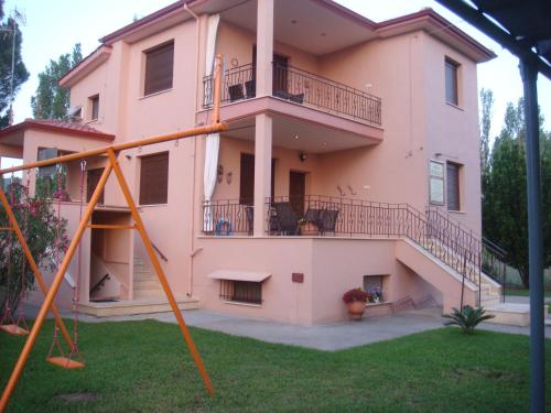 錫基亞的住宿－Villa Angela，粉红色的房子,前面设有一个游乐场
